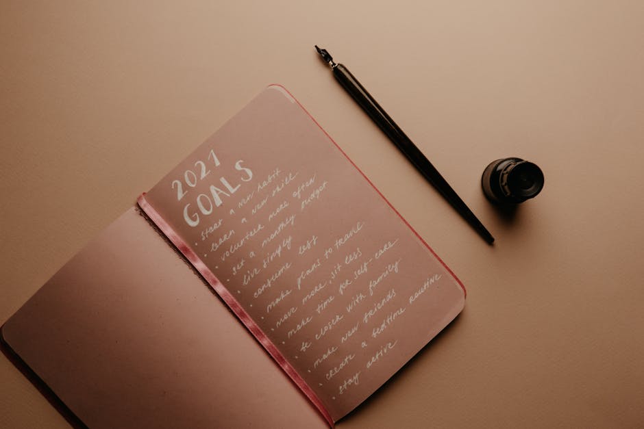 A notebook with '2021 Goals' written in calligraphy, featuring a pen and ink bottle.
